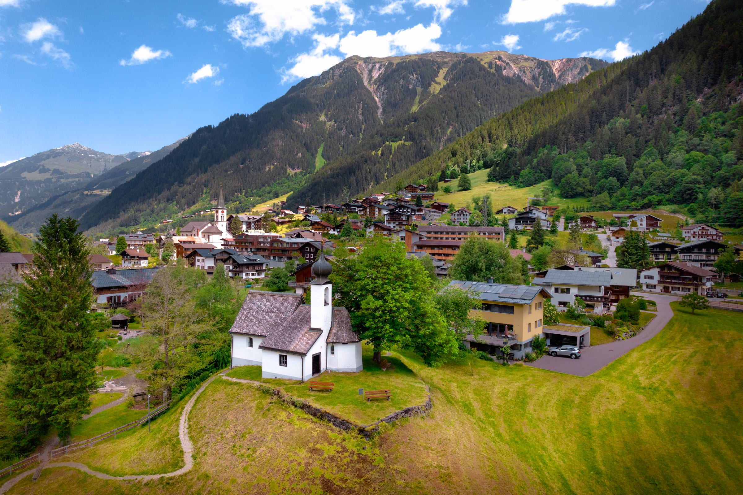 Gaschurn im Sommer — Luftaufnahme mit Kirche und Bergen
